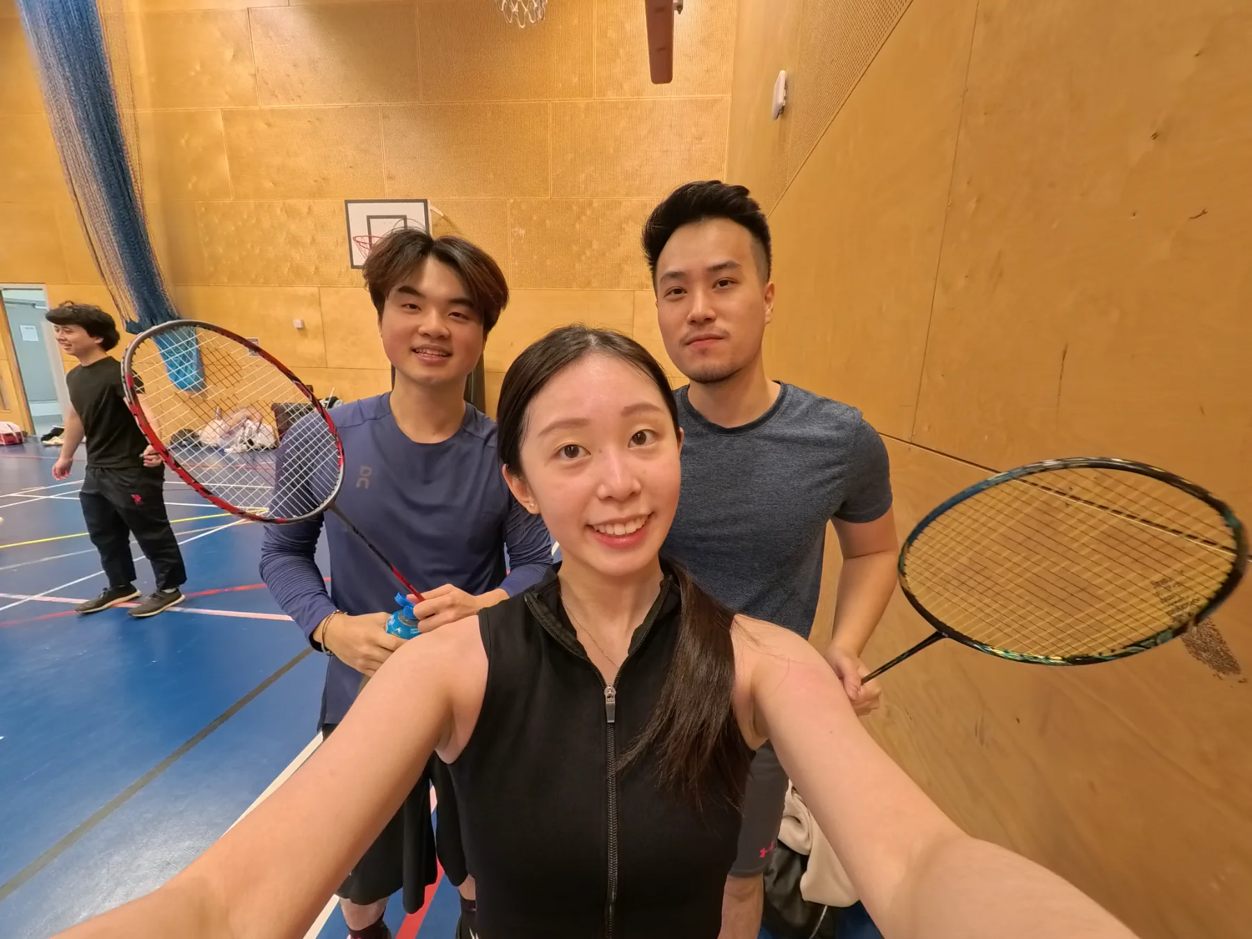 Wilson and friends with badminton rackets in an indoor court