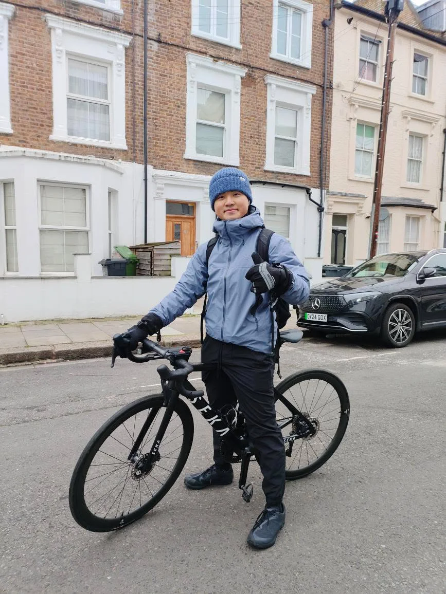 Wilson standing with his road bike on a London street